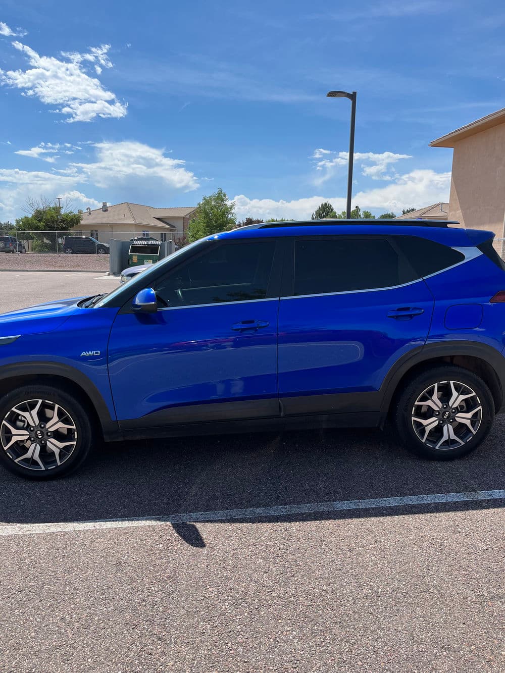 Blue SUV parked in a sunny lot, showcasing sleek design and stylish alloy wheels.